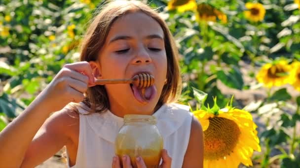Дитина їсть мед з квітів. Вибірковий фокус . — стокове відео