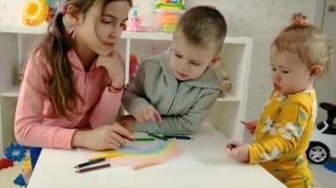 Çocuklar birlikte bir gökkuşağı çiziyorlar. Seçici odak.