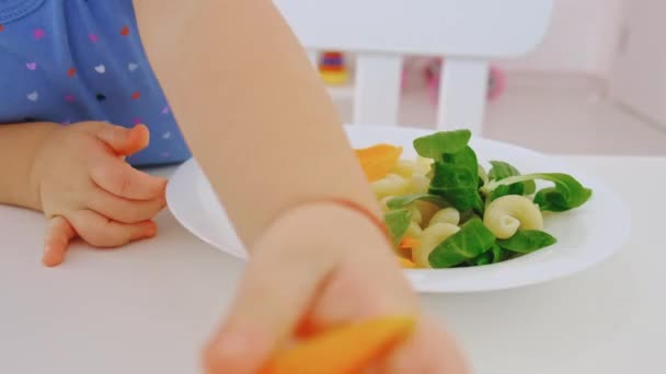 El niño come pasta y verduras. Enfoque selectivo. — Vídeo de stock