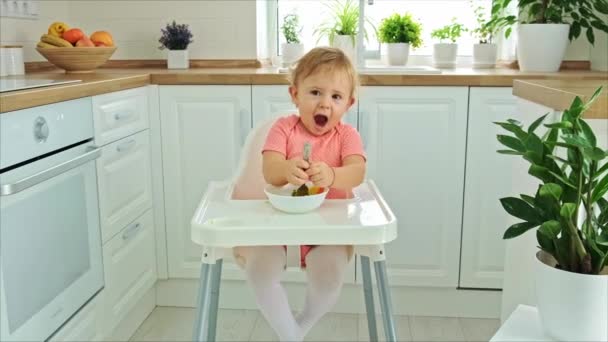 Baby isst Gemüse auf einem Stuhl. Selektiver Fokus. — Stockvideo