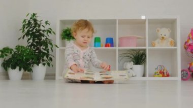 Bebek odada bir kitap okuyor. Seçici odaklanma. Çocuk.