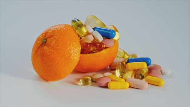 Vitamine mit Orangen auf weißem Hintergrund. Selektiver Fokus. — Stockvideo