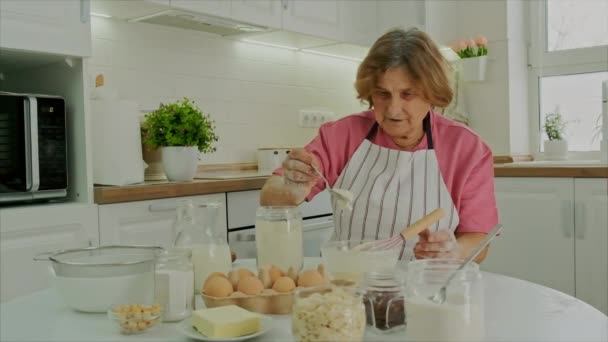 Babcia przygotowuje ciasto w kuchni. Skupienie selektywne. — Wideo stockowe