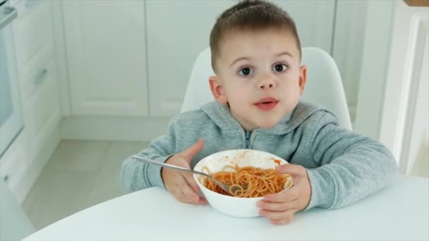 Il bambino mangia gli spaghetti in cucina. Focus selettivo. — Video Stock