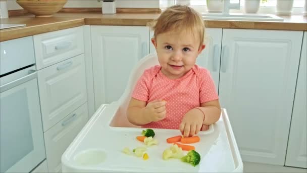 Ребенок ест овощи на стуле. Селективный фокус. — стоковое видео