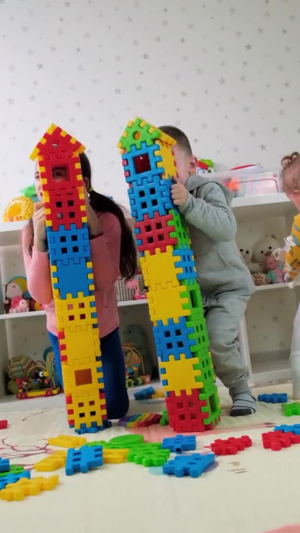 Barn leker sammen som konstruktører bygger hus. Selektivt fokus. – stockvideo