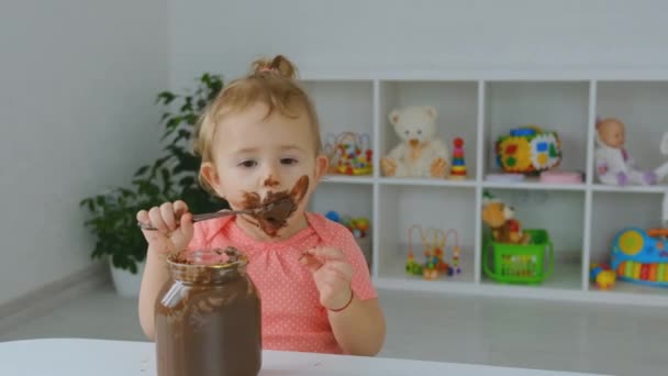 Dítě jí čokoládovou pomazánku. Selektivní zaměření. — Stock video