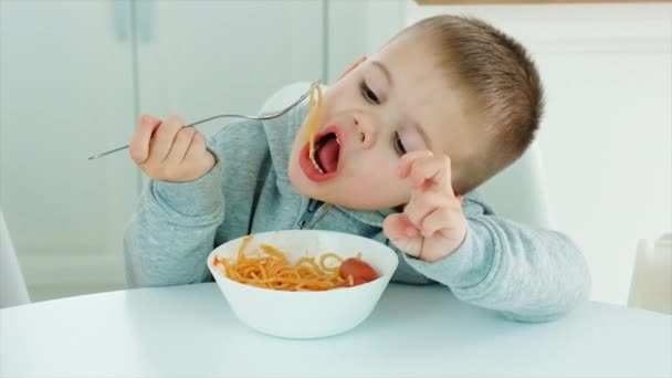 Dziecko je spaghetti w kuchni. Skupienie selektywne. — Wideo stockowe