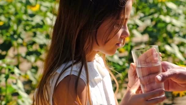 Ο πατέρας δίνει ένα ποτήρι νερό στο παιδί. Επιλεκτική εστίαση. — Αρχείο Βίντεο