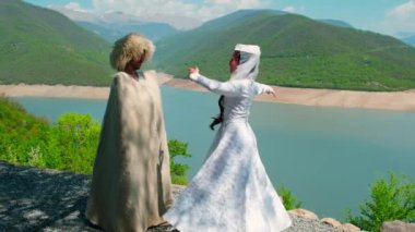 Bir kız ve papakha giymiş bir adam ve ulusal Gürcü kostümü. Seçici odak.