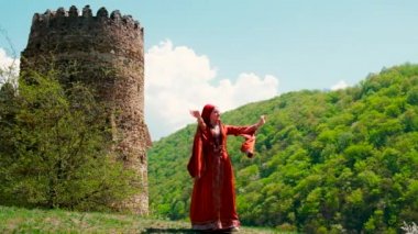 A girl in a national Georgian red dress is dancing. Selective focus.