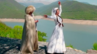 Bir kız ve papakha giymiş bir adam ve ulusal Gürcü kostümü. Seçici odak.