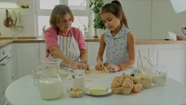 Avó e criança cozinham massa juntos. Foco seletivo. — Vídeo de Stock