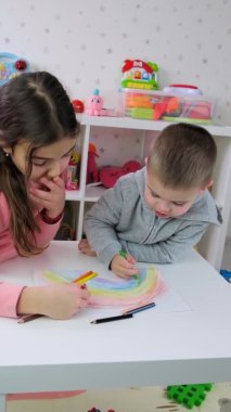 Çocuklar birlikte bir gökkuşağı çiziyorlar. Seçici odak.