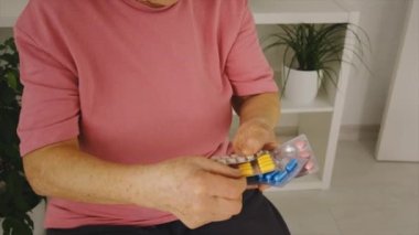 Yaşlı bir kadın hap içiyor. Seçici odak.