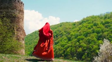 A girl in a national Georgian red dress is dancing. Selective focus.
