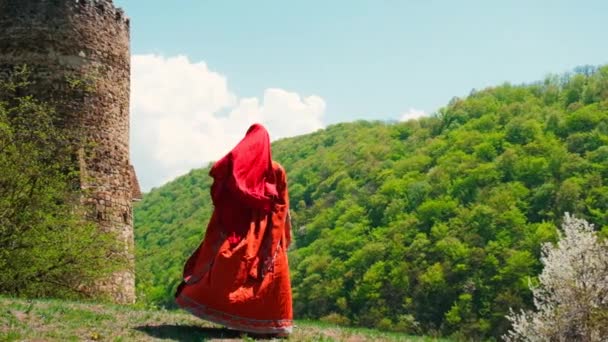 Een meisje in een nationale Georgische rode jurk danst. Selectieve focus. — Stockvideo