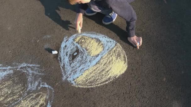 Children draw with chalk on asyalte. Selective focus. — Stockvideo