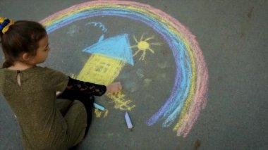 Bir çocuk kaldırıma tebeşirle Ukrayna bayrağını çekiyor. Seçici odaklanma. Çocuk.