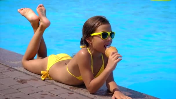 那孩子在游泳池边吃冰淇淋 有选择的重点 — 图库视频影像