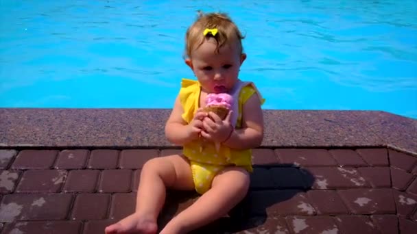 子供はプールの近くでアイスクリームを食べる 選択的フォーカス キッド — ストック動画