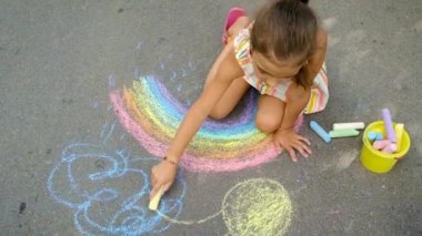 Çocuk tebeşirle bir gökkuşağı çiziyor. Seçici odaklanma. Çocuk.