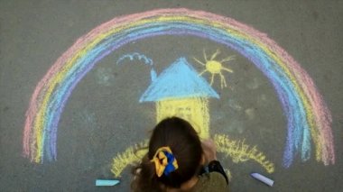 Bir çocuk kaldırıma tebeşirle Ukrayna bayrağını çekiyor. Seçici odaklanma. Çocuk.