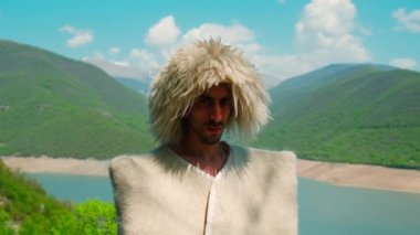 Papakha giymiş bir adam ve ulusal Gürcü kostümü. Seçici odaklanma. İnsanlar.