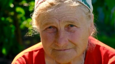 Yaşlı kadın portresi yukarı bakıyor. Seçici odaklanma. Doğa.