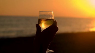 Gün batımında deniz kenarında bir bardak şarap. Seçici odaklanma. İç..