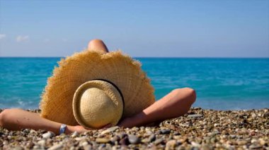 Şapkalı kız plajda yatıyor. Seçici odaklanma. Yaz.