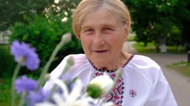 Yaşlı kadının çiçeklere alerjisi var. Seçici odaklanma. İnsanlar.