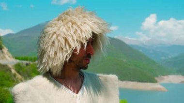 Papakha giymiş bir adam ve ulusal Gürcü kostümü. Seçici odaklanma. İnsanlar.