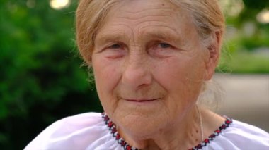 Yaşlı kadın portresi yukarı bakıyor. Seçici odaklanma. Doğa.