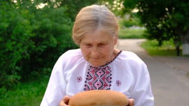 Elinde Ukrayna ekmeği olan bir büyükanne. Seçici odaklanma. Yiyecek..