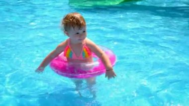 Bir çocuk çemberli bir havuzda yüzer. Seçici odaklanma. Bebeğim..
