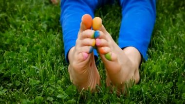 Child on the grass feet paint drawing. Selective focus. Kid.