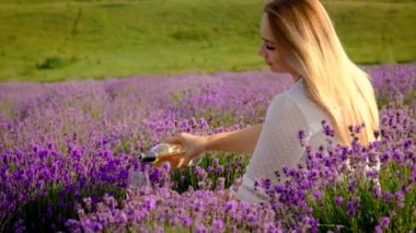 A woman drinks wine in a lavender field. Selective focus. Food.