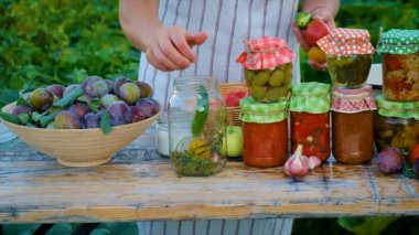 Senior woman makes preservation of vegetables. Selective focus. People.