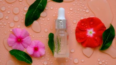 Background with water drops cosmetics in a bottle and flowers. Hyaluronic acid. Spa.