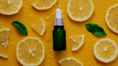 Lemon essential oil on a yellow background with water drops. Selective focus. Food.