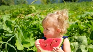 The child eThe child eats watermelon in summer. Selective focus.ats watermelon in summer. Selective focus. Kid.
