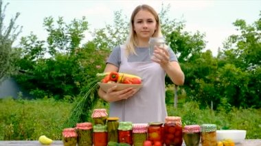 A woman preserves vegetables in jars. Selective focus. Food.