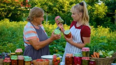 Women with jar preserved vegetables for the winter mother and daughter. Food.