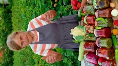 Senior woman makes preservation of vegetables. Selective focus. People.