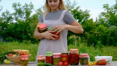A woman preserves vegetables in jars. Selective focus. Food.