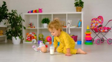 The child drinks milk in the room. Selective focus. Kid.