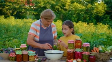 Women with jar preserved vegetables for the winter mother and daughter. Food.