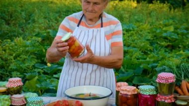 Senior woman makes preservation of vegetables. Selective focus. People.