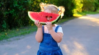 The child eats watermelon in summer. Selective focus. Kid.